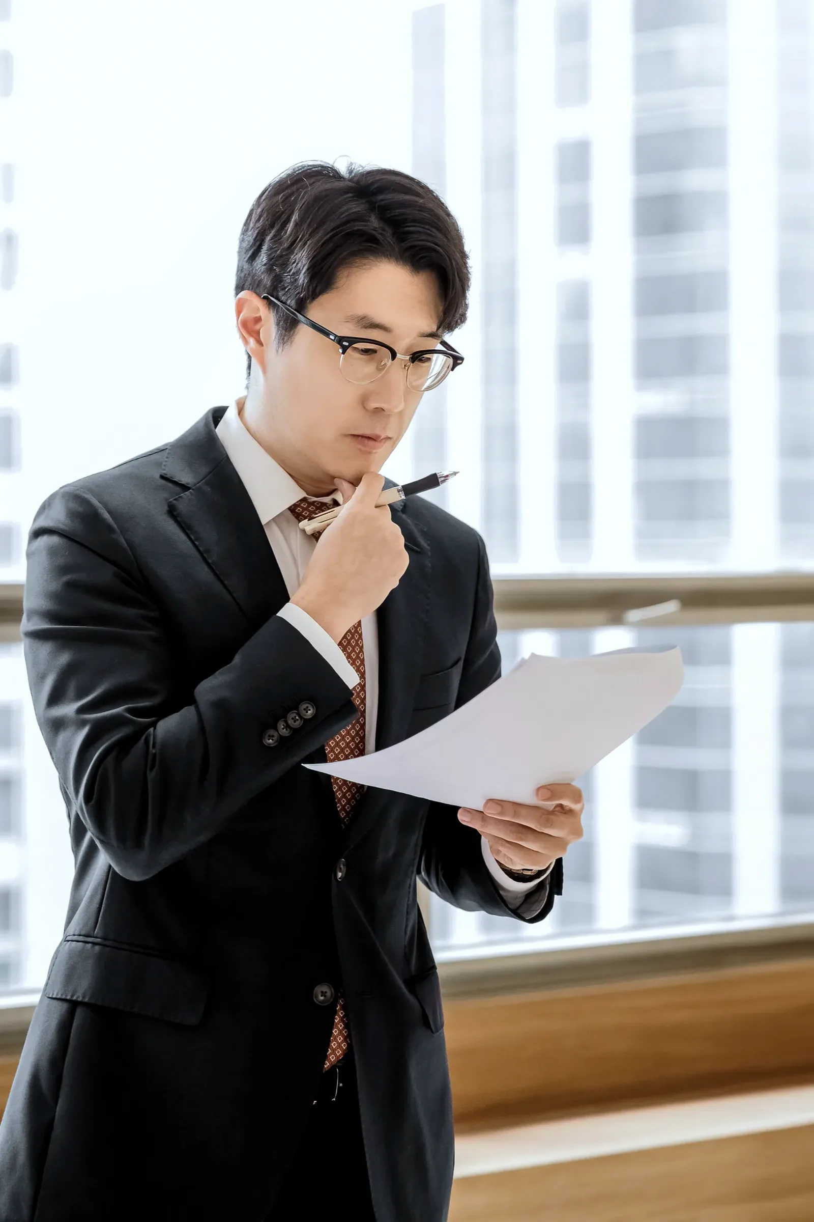 서류를 들고 검토하는 박진우 대표변호사
